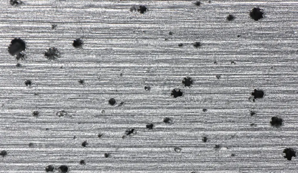 High magnification view of micro-void defects on machined cast aluminum sealing surface resulting in leak test failure High magnification view of micro-void defects on machined cast aluminum sealing surface resulting in leak test failure