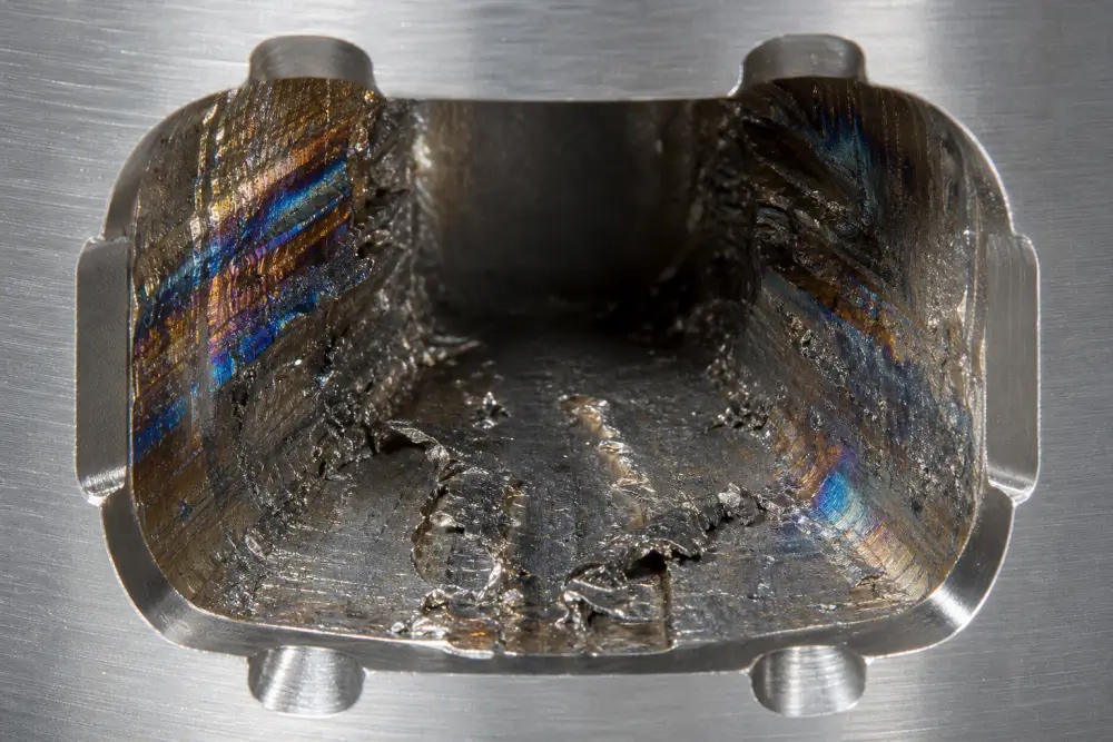 Microscopic view of chip packing and thermal galling failure inside a deep blind CNC undercut slot Microscopic view of chip packing and thermal galling failure inside a deep blind CNC undercut slot